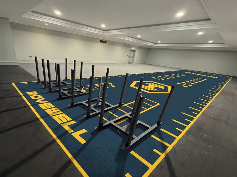 brushing gym turf with a stiff bristle broom for maintenance